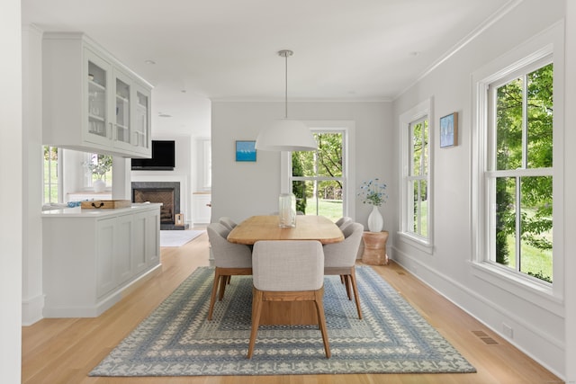289 Wahackme Rd, New Canaan, CT 06840 - dining room featuring light wood finished floors, a fireplace, and ornamental molding