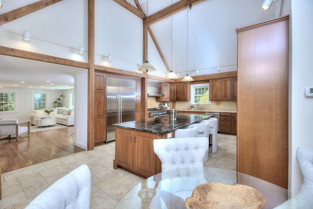 29 Bradley Rd, Weston, CT 06883 - kitchen featuring high end appliances, brown cabinets, high vaulted ceiling, a center island, and dark stone countertops