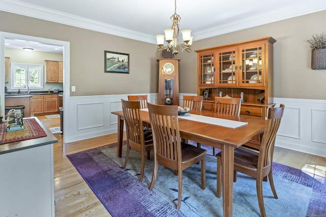 18 Jeans Ct, Woodstock, CT 06281 - dining space featuring a chandelier, light wood-style flooring, wainscoting, ornamental molding, and a decorative wall