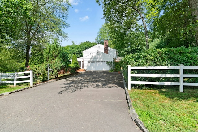 11 Old Kings Hwy, New Canaan, CT 06840 - view of front facade with driveway, an attached garage, and a chimney