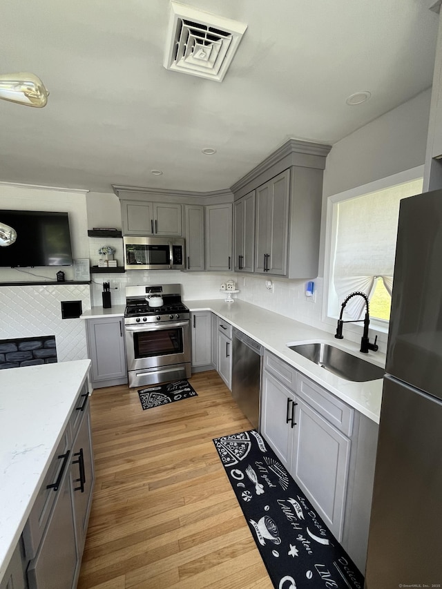 538 Winthrop Rd, Deep River, CT 06417 - kitchen featuring stainless steel appliances, gray cabinetry, light wood-style floors, decorative backsplash, and open shelves
