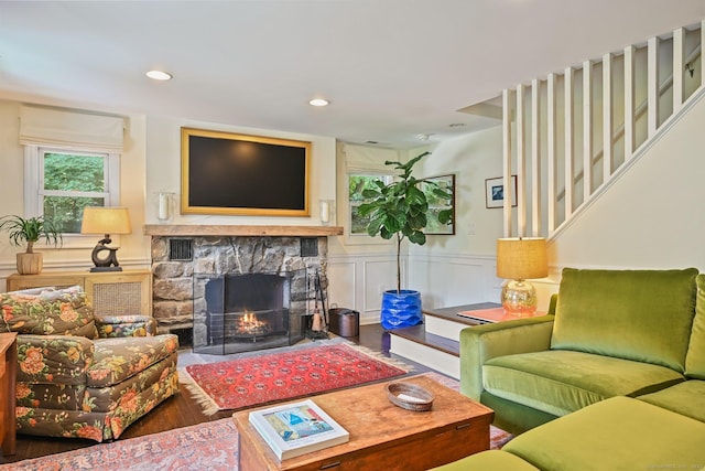 311 Wilton Rd E, Ridgefield, CT 06877 - living room with a stone fireplace, wood finished floors, wainscoting, stairway, and recessed lighting