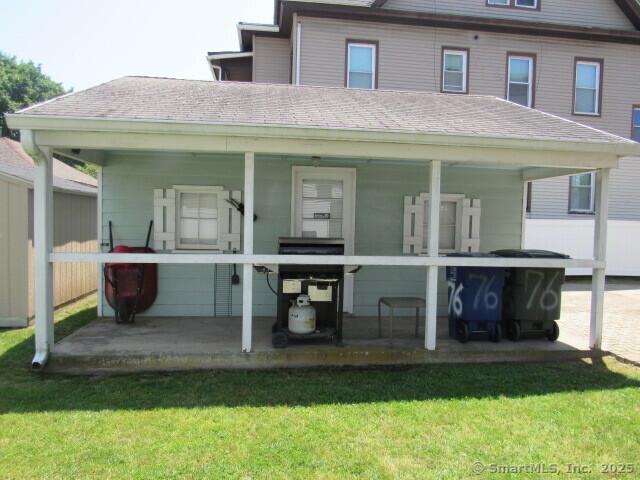 76 Porter St, Bridgeport, CT 06606 - rear view of house with a lawn and roof with shingles