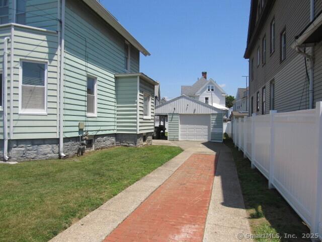 76 Porter St, Bridgeport, CT 06606 - view of property exterior with driveway, a detached garage, and an outbuilding
