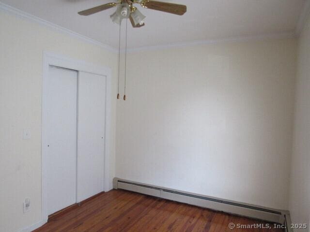 76 Porter St, Bridgeport, CT 06606 - unfurnished bedroom featuring baseboard heating, crown molding, wood finished floors, a closet, and a ceiling fan