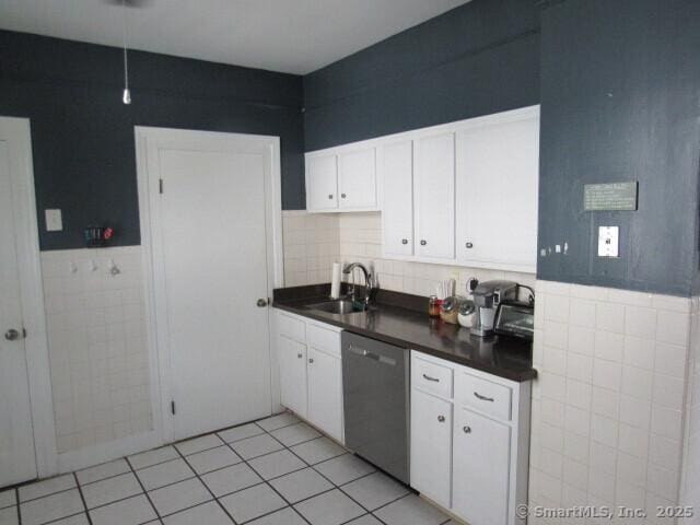 76 Porter St, Bridgeport, CT 06606 - kitchen with dishwasher, tile walls, dark countertops, white cabinets, and wainscoting