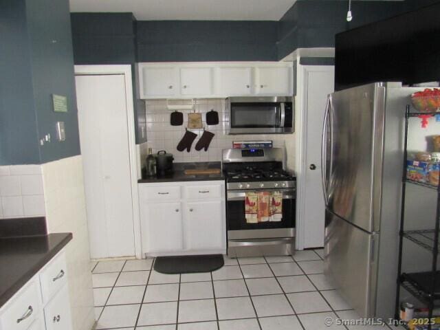 76 Porter St, Bridgeport, CT 06606 - kitchen with appliances with stainless steel finishes, dark countertops, backsplash, and white cabinets