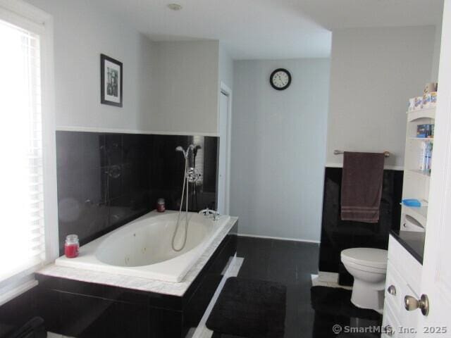 76 Porter St, Bridgeport, CT 06606 - bathroom featuring healthy amount of natural light, a tub with jets, and vanity