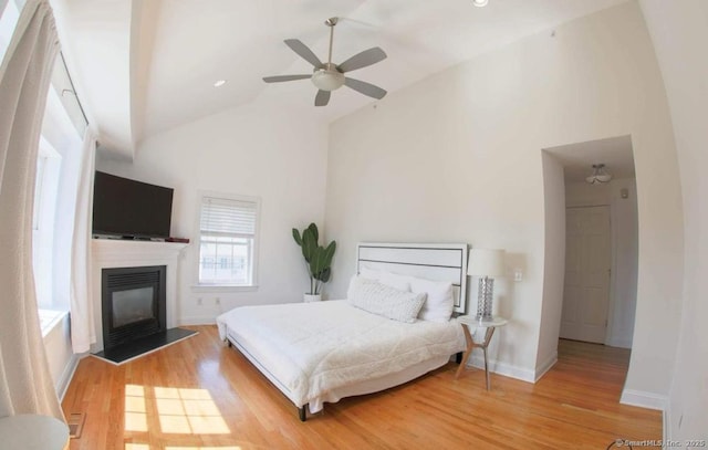 205 Hope St Unit 5, Stamford, CT 06906 - bedroom featuring wood finished floors, a glass covered fireplace, high vaulted ceiling, and a ceiling fan
