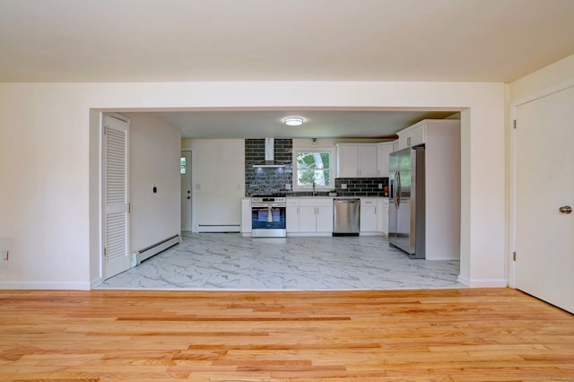 6 Overbrook Dr, East Hartford, CT 06118 - kitchen with appliances with stainless steel finishes, a baseboard heating unit, wall chimney exhaust hood, light marble finish floors, and white cabinetry