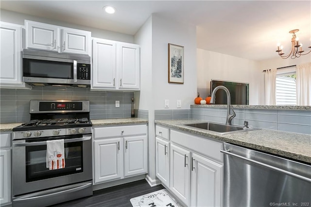1802 Larson Dr Unit 1802, Danbury, CT 06810 - kitchen featuring appliances with stainless steel finishes, white cabinetry, dark wood finished floors, tasteful backsplash, and a chandelier