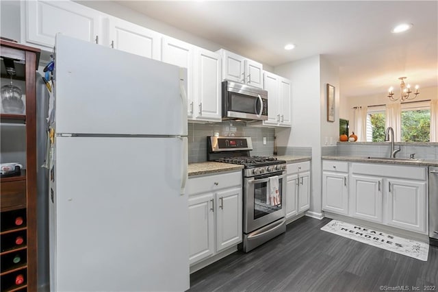 1802 Larson Dr Unit 1802, Danbury, CT 06810 - kitchen featuring appliances with stainless steel finishes, backsplash, dark wood-type flooring, white cabinetry, and a chandelier