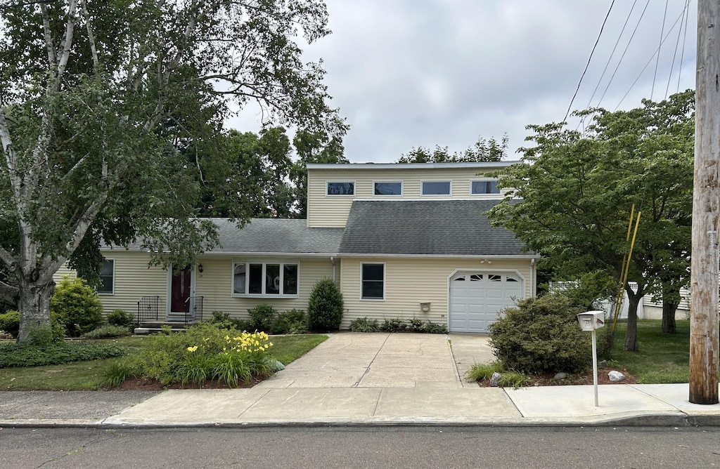 25 Andrus Dr, Milford, CT 06461 - view of front facade featuring concrete driveway, a garage, and roof with shingles