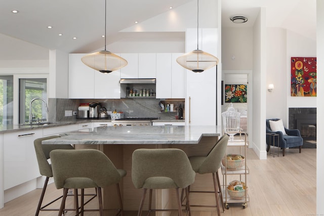 35 Emmons Ln, North Canaan, CT 06018 - kitchen with modern cabinets, white cabinetry, high vaulted ceiling, a kitchen breakfast bar, and backsplash