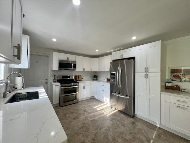 65 Patchen St, Stratford, CT 06615 - kitchen with stainless steel appliances, white cabinets, light stone countertops, recessed lighting, and backsplash