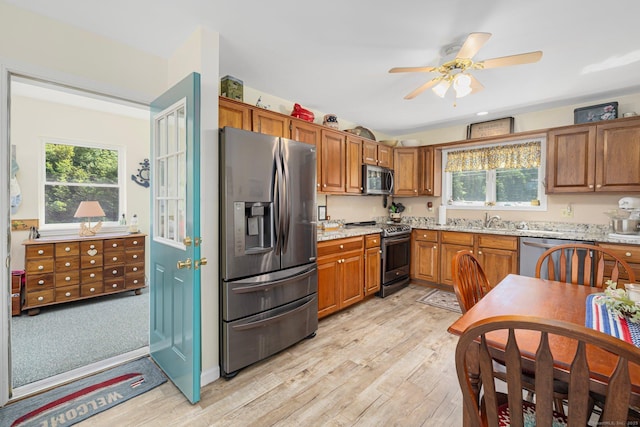 138 S Shore Rd, Killingly, CT 06241 - kitchen featuring stainless steel appliances, light wood-style floors, brown cabinets, and light stone counters