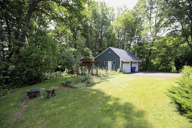 9 River Bend Ln, Windsor, CT 06095 - view of grassy yard featuring driveway, a garden, an outbuilding, and a forest view
