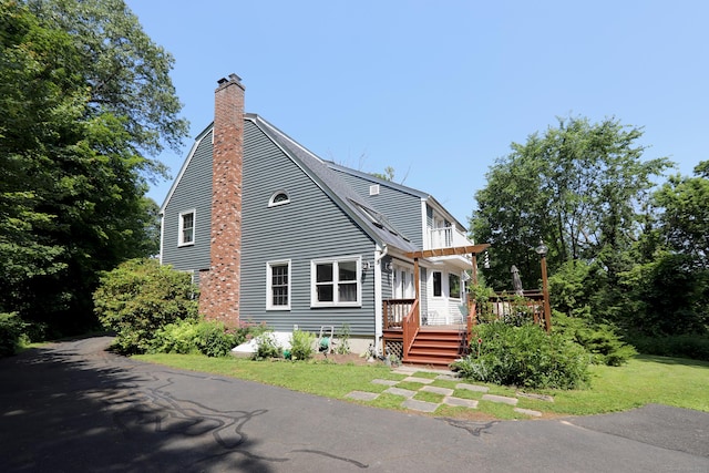 9 River Bend Ln, Windsor, CT 06095 - view of front of home with a chimney, a wooden deck, and a front yard