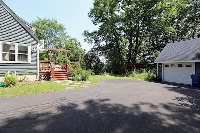 9 River Bend Ln, Windsor, CT 06095 - view of side of home with asphalt driveway, a deck, an outdoor structure, and a detached garage