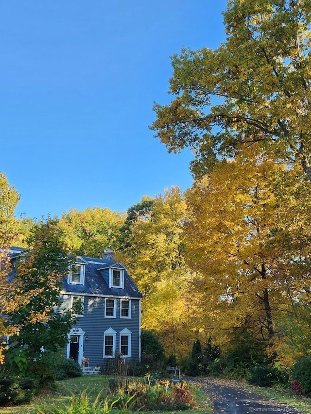 9 River Bend Ln, Windsor, CT 06095 - view of property exterior with a chimney and a wooded view