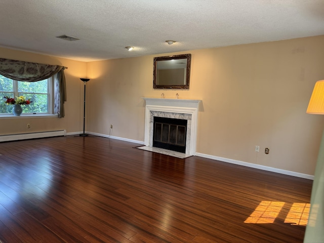 16 Snow Rdg S, Middletown, CT 06457 - unfurnished living room featuring hardwood / wood-style floors, a baseboard radiator, a fireplace, and a textured ceiling