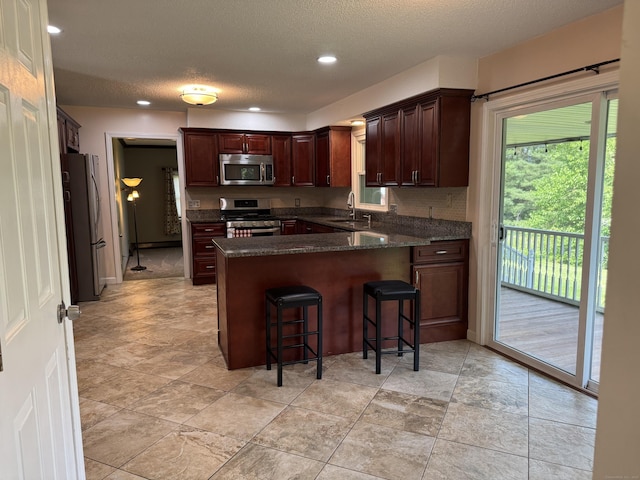 16 Snow Rdg S, Middletown, CT 06457 - kitchen featuring appliances with stainless steel finishes, a peninsula, a breakfast bar area, a textured ceiling, and recessed lighting