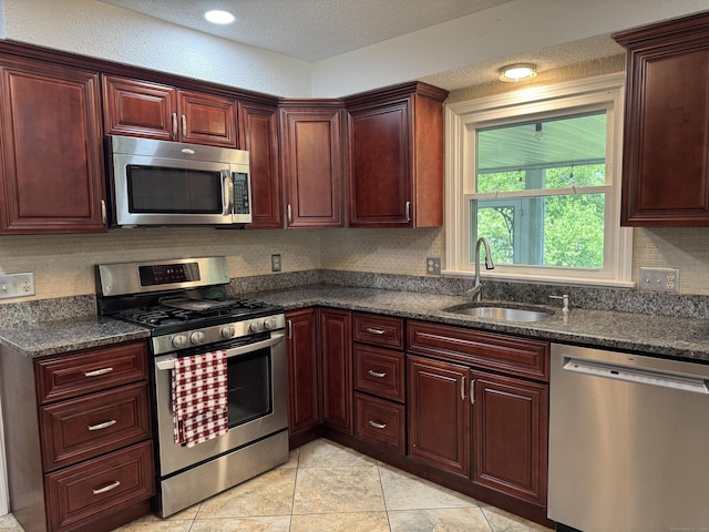 16 Snow Rdg S, Middletown, CT 06457 - kitchen featuring appliances with stainless steel finishes, reddish brown cabinets, tasteful backsplash, light tile patterned flooring, and a textured ceiling