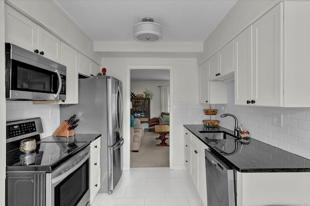 148 Conestoga Way Unit 148, Glastonbury, CT 06033 - kitchen featuring appliances with stainless steel finishes, white cabinetry, backsplash, light colored carpet, and a textured ceiling