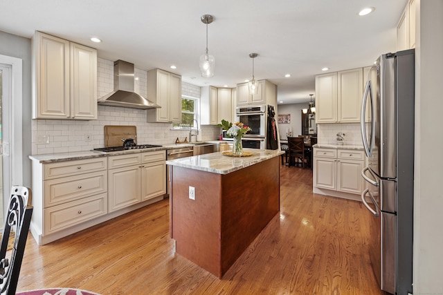 21 Derek Ln, Windsor, CT 06095 - kitchen with wall chimney range hood, stainless steel appliances, light wood finished floors, a center island, and recessed lighting