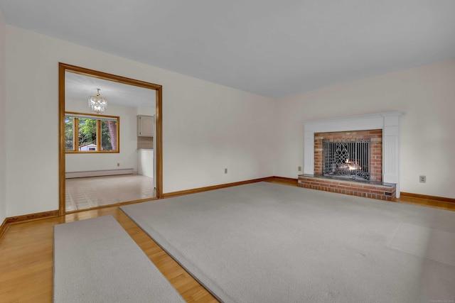 108 Sandelwood Dr, Madison, CT 06443 - unfurnished living room featuring baseboard heating, a fireplace, light wood-style flooring, and a chandelier