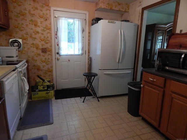 85 Bradford Rd, Torrington, CT 06790 - kitchen featuring white appliances, wallpapered walls, brown cabinetry, and brick patterned flooring