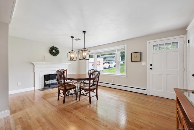 82 Shipman Dr, Glastonbury, CT 06033 - dining room with a baseboard radiator, light wood-type flooring, and a fireplace with flush hearth
