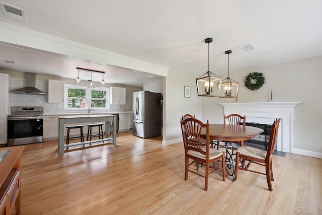 82 Shipman Dr, Glastonbury, CT 06033 - dining area with light wood-style floors and a fireplace