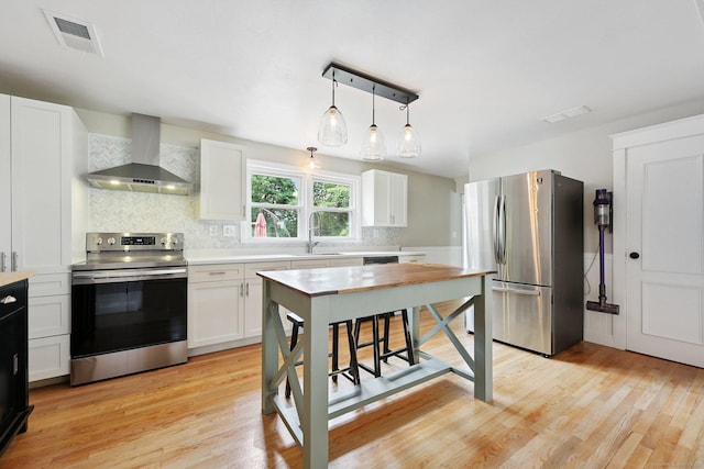 82 Shipman Dr, Glastonbury, CT 06033 - kitchen with stainless steel appliances, wall chimney range hood, decorative backsplash, light countertops, and light wood-style flooring