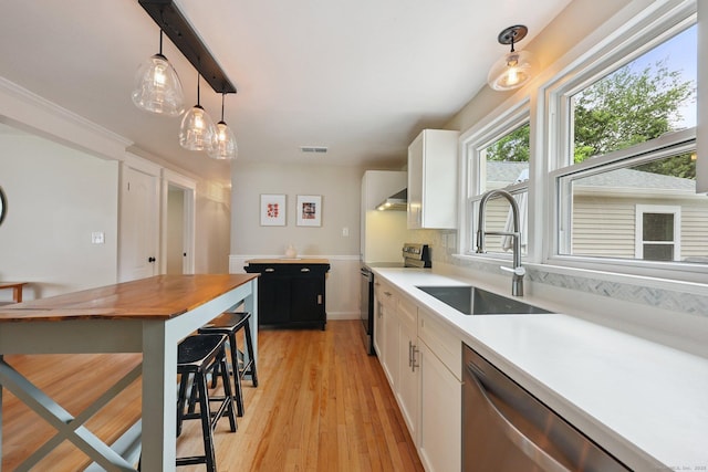 82 Shipman Dr, Glastonbury, CT 06033 - kitchen featuring appliances with stainless steel finishes, light wood-style flooring, white cabinetry, and pendant lighting