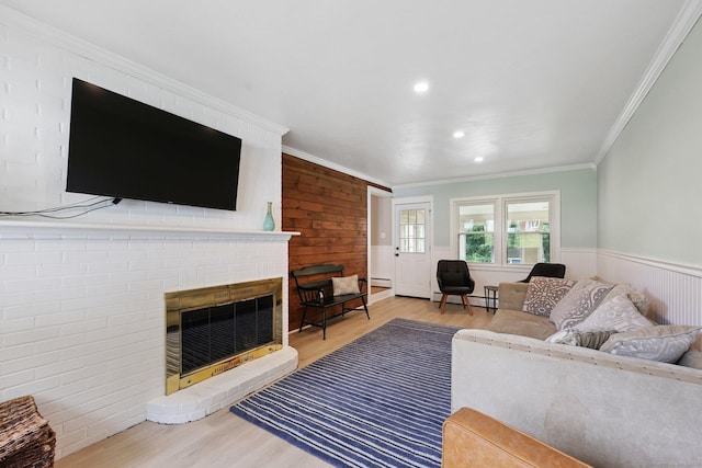 82 Shipman Dr, Glastonbury, CT 06033 - living room featuring wood finished floors, crown molding, a brick fireplace, a wainscoted wall, and recessed lighting