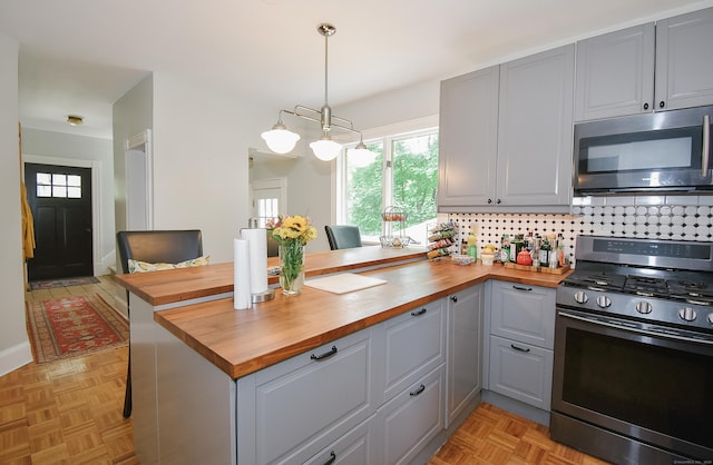 17 Adams St, Winchester, CT 06098 - kitchen with butcher block countertops, stainless steel appliances, gray cabinetry, and a peninsula