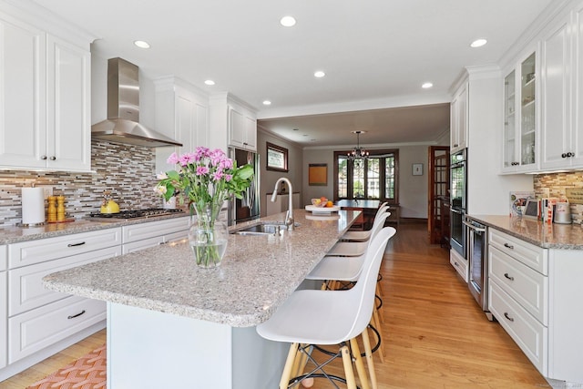 110 Westwood Rd, New Haven, CT 06515 - kitchen with wall chimney exhaust hood, stainless steel appliances, light wood-type flooring, white cabinetry, and recessed lighting