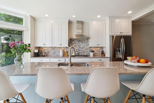 110 Westwood Rd, New Haven, CT 06515 - kitchen with wall chimney exhaust hood, stainless steel appliances, white cabinets, backsplash, and light stone countertops