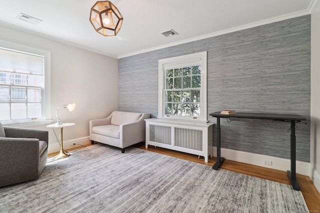 110 Westwood Rd, New Haven, CT 06515 - sitting room featuring radiator, wood finished floors, ornamental molding, an accent wall, and wallpapered walls
