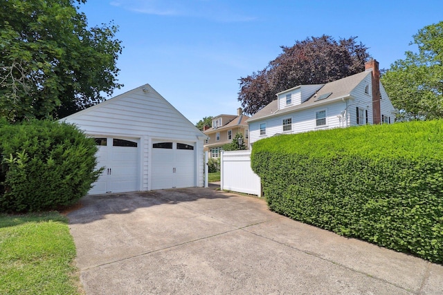 110 Westwood Rd, New Haven, CT 06515 - view of home's exterior featuring a detached garage, an outdoor structure, and a chimney
