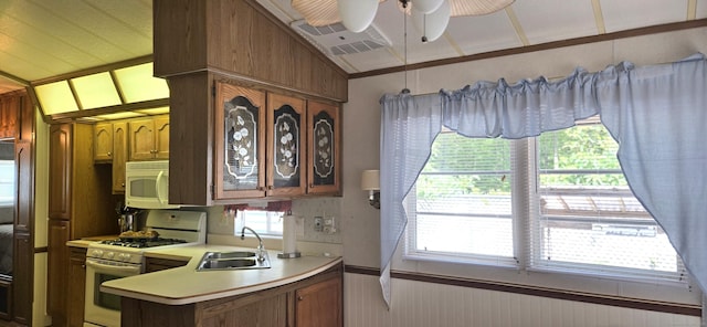306 Old Colchester Rd Unit 197, Salem, CT 06420 - kitchen featuring white appliances, light countertops, ceiling fan, brown cabinetry, and a peninsula