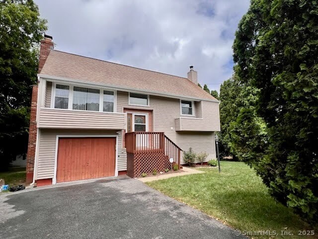 39 Wells Ave, Shelton, CT 06484 - split foyer home with a chimney, asphalt driveway, a garage, and a front yard