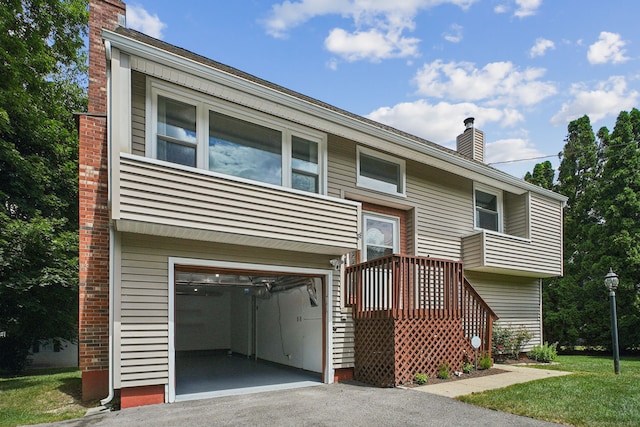 39 Wells Ave, Shelton, CT 06484 - split foyer home featuring driveway, a chimney, a garage, and a front lawn