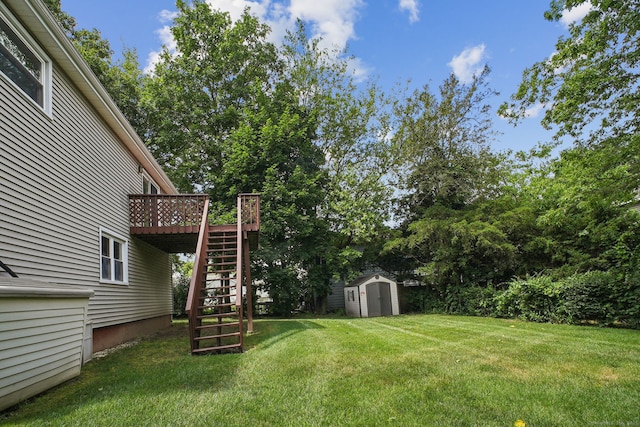 39 Wells Ave, Shelton, CT 06484 - view of green lawn featuring stairway, a storage unit, a deck, and view of wooded area