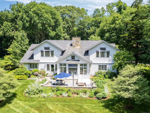 192 Catalpa Rd, Wilton, CT 06897 - rear view of house featuring a lawn, entry steps, a chimney, a patio area, and view of scattered trees