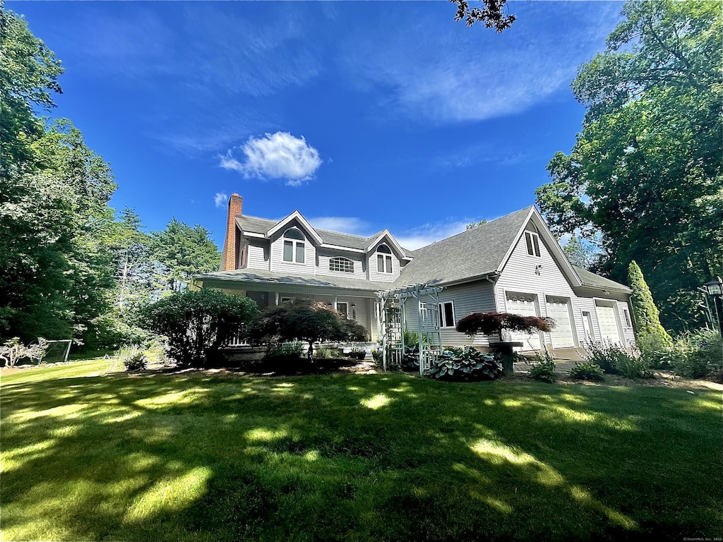 8 Brendans Way, Granby, CT 06035 - view of front of house featuring a front lawn, a chimney, and an attached garage