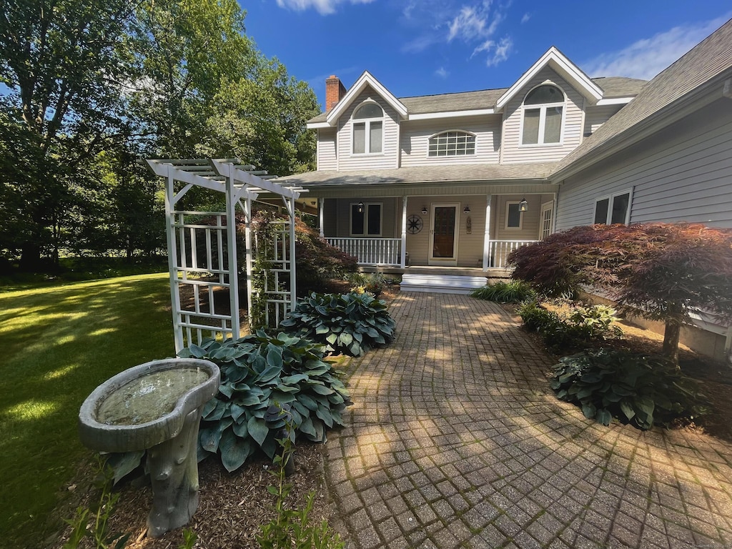 8 Brendans Way, Granby, CT 06035 - back of property with a chimney, a porch, a lawn, and a pergola