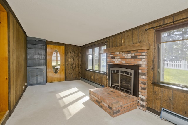 282 Halladay Dr, Suffield, CT 06093 - unfurnished living room featuring a baseboard heating unit, wood walls, light colored carpet, and a fireplace