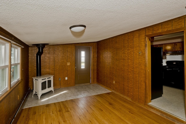 282 Halladay Dr, Suffield, CT 06093 - entrance foyer with wood finished floors, a wood stove, baseboard heating, and a textured ceiling